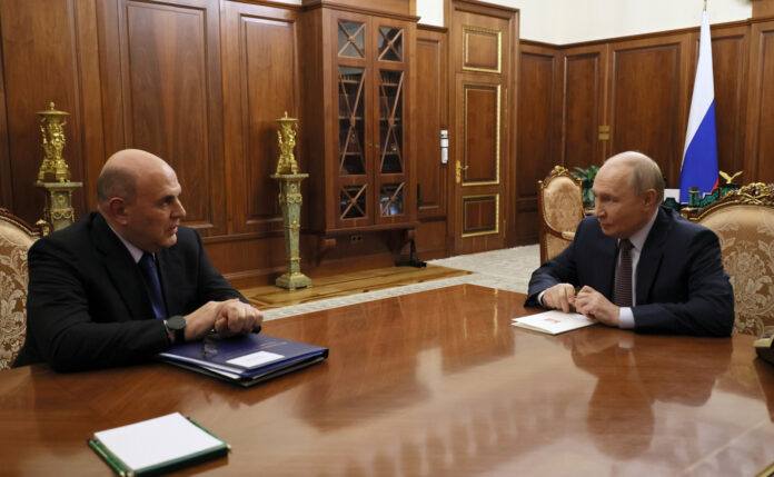 Prime Minister Mikhail Mishustin and President Vladimir Putin seated across a table at the Kremlin