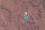 Blue and white potash evaporation ponds beside a river bend in the red rock desert near Moab, Utah, seen from the International Space Station