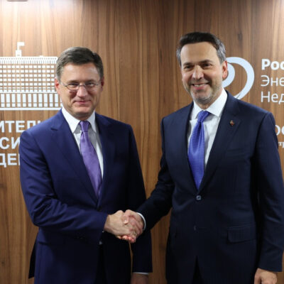 Russian Deputy Prime Minister Alexander Novak and Turkish Energy Minister Alparslan Bayraktar shaking hands in front of a Russian Energy Week 2026 backdrop