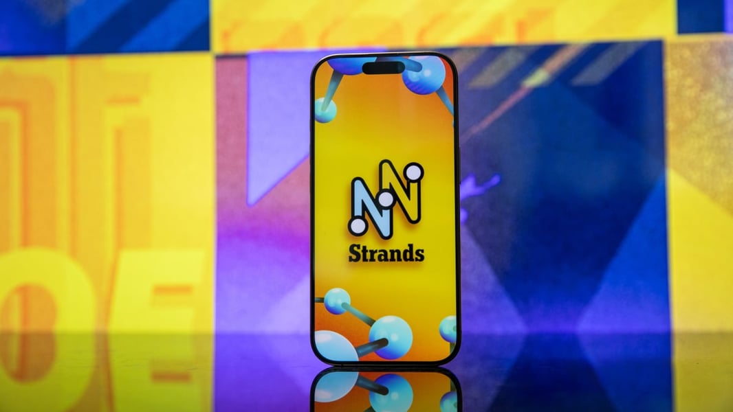 Smartphone displaying the Strands game logo against a colorful background