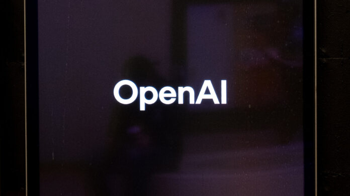 The white OpenAI logo glows on a dark screen