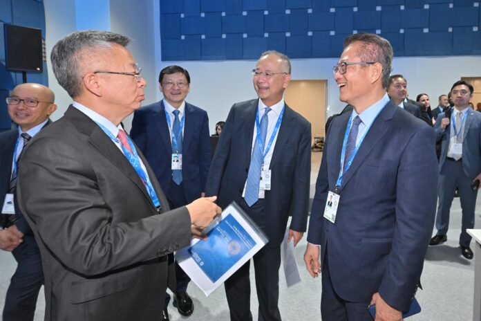 Hong Kong Financial Secretary Paul Chan laughing with HKMA chief Eddie Yue and IMF Deputy Managing Director Bo Li at the IMF-World Bank annual meetings in Bangkok