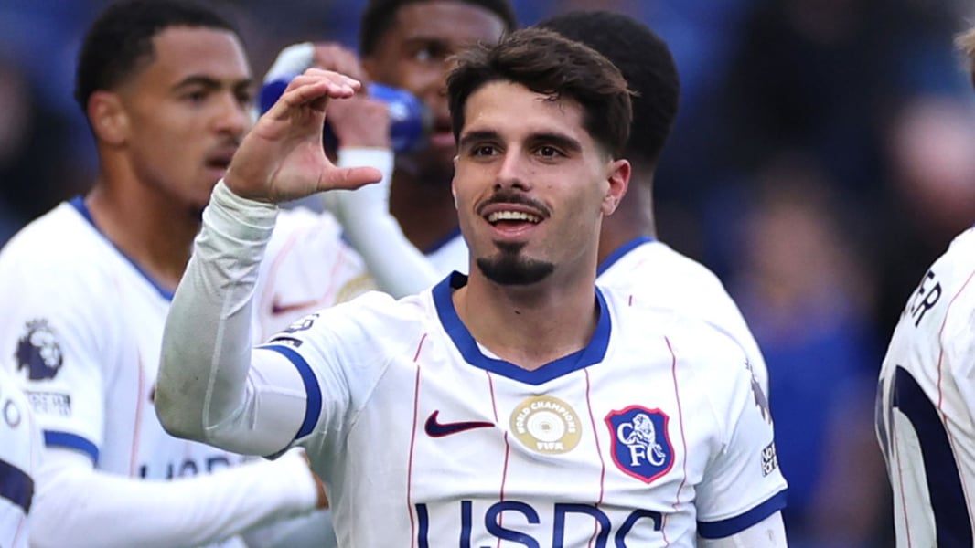Chelsea forward Pedro Neto raises a hand in celebration after scoring at Everton