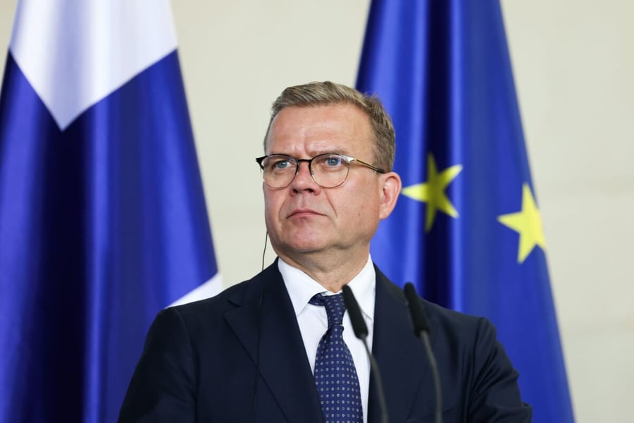 Finnish Prime Minister Petteri Orpo in front of Finnish and EU flags during a press statement