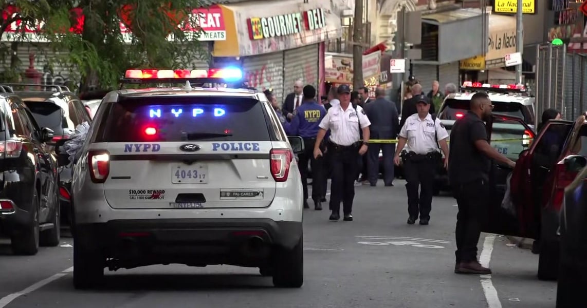 NYPD officers and a police car at the scene in Marble Hill after an ICE officer shot a man