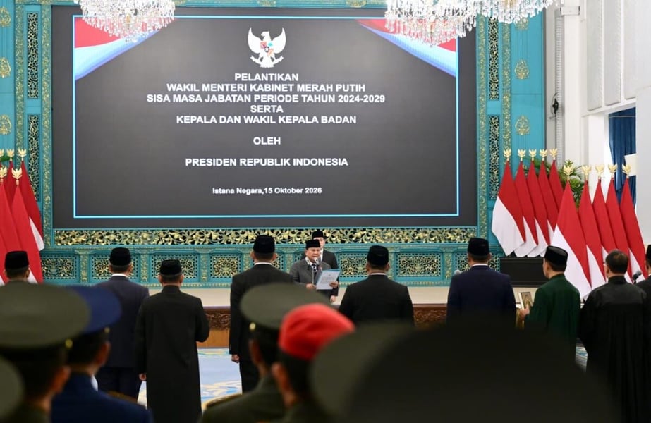 President Prabowo Subianto stands at a lectern in the State Palace in Jakarta as officials face him during an inauguration ceremony