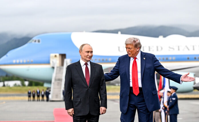 Vladimir Putin and Donald Trump standing on the tarmac in front of Air Force One in Anchorage, Alaska, with Trump gesturing