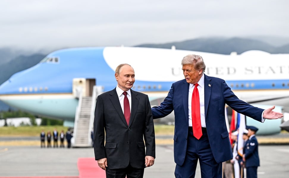 Vladimir Putin and Donald Trump standing on the tarmac in front of Air Force One in Anchorage, Alaska, with Trump gesturing