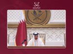 Qatar's Emir Sheikh Tamim bin Hamad Al Thani seated at a microphone before the national flag as he addresses the Shura Council