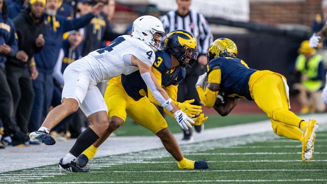 Michigan's Rod Moore Jr. holds the ball on the sideline against Penn State