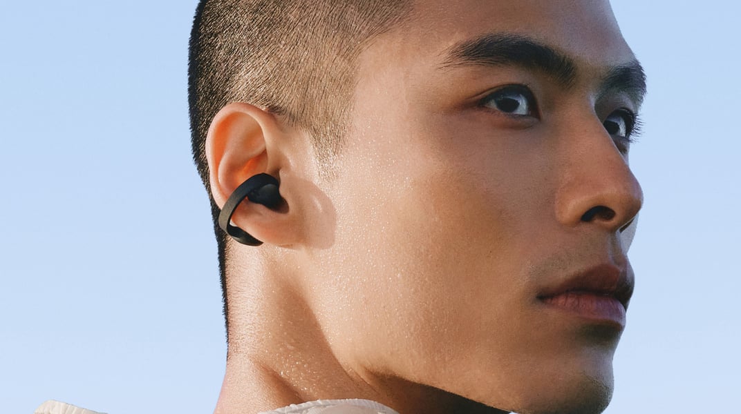 Close-up of a black Galaxy Buds On earbud clipped around a person's ear