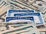 Three Social Security cards fanned out on a pile of 20-dollar bills