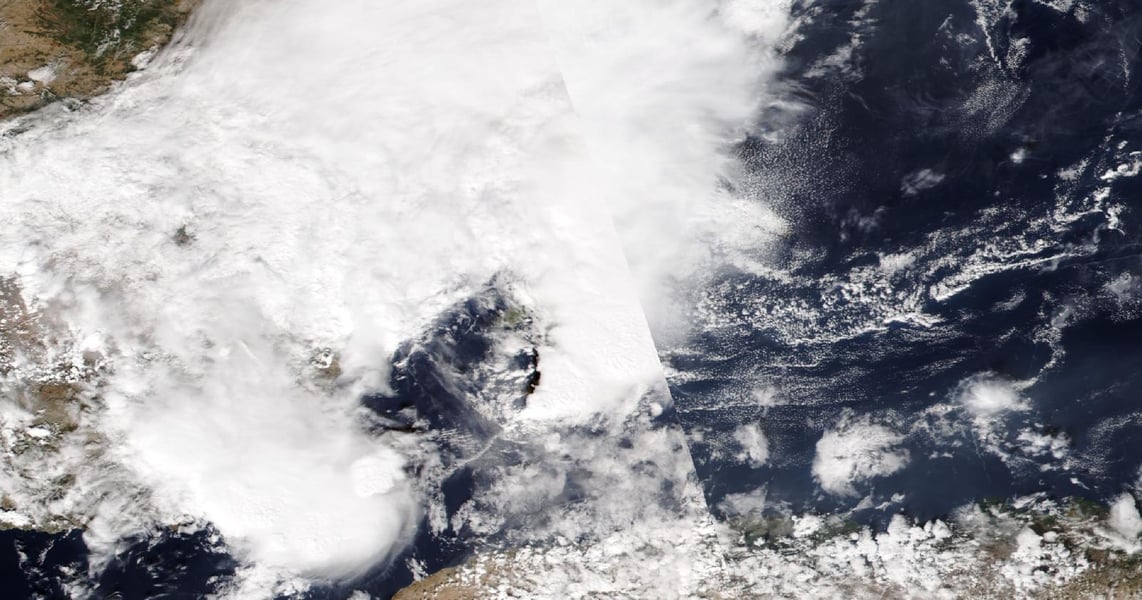 Satellite image of thick white cloud covering eastern Spain and the sea off its coast, with clear sea to the east