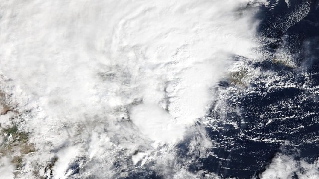Close satellite view of thick white cloud over eastern Spain and the western Mediterranean, with dark sea showing at the right edge