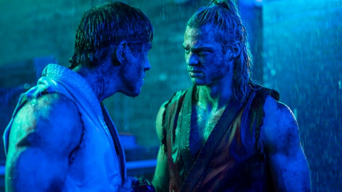 Andrew Koji and Noah Centineo face each other in a rain-soaked blue-lit scene from Paramount's Street Fighter