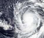 Satellite view of Super Typhoon Champi's cloud mass and eye just west of Guam, whose coastline is outlined at right