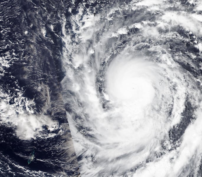 Satellite view of Super Typhoon Champi's cloud mass and eye just west of Guam, whose coastline is outlined at right