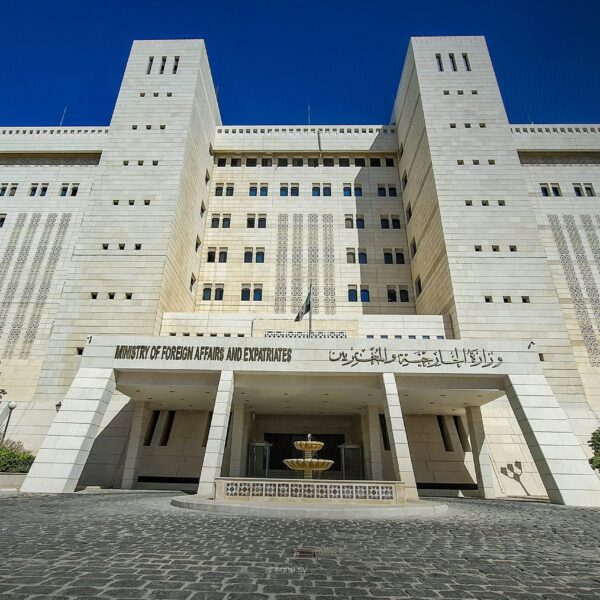 Front of the Syrian Ministry of Foreign Affairs and Expatriates building under a clear blue sky