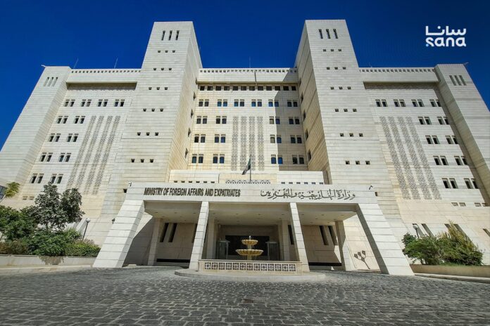 Front of the Syrian Ministry of Foreign Affairs and Expatriates building under a clear blue sky