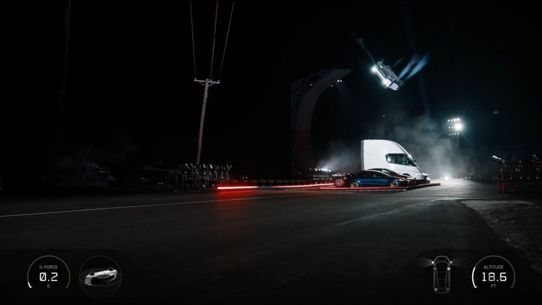 Tesla Roadster prototype airborne above a row of Tesla vehicles at night during the October 15, 2026 demonstration in Texas