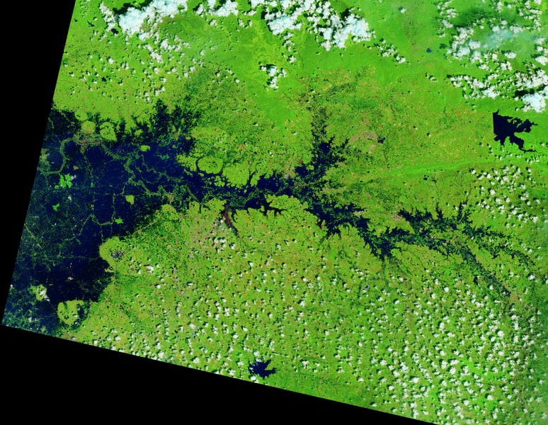 False-color Landsat image of Thailand with dark blue floodwater filling a river valley amid green vegetation