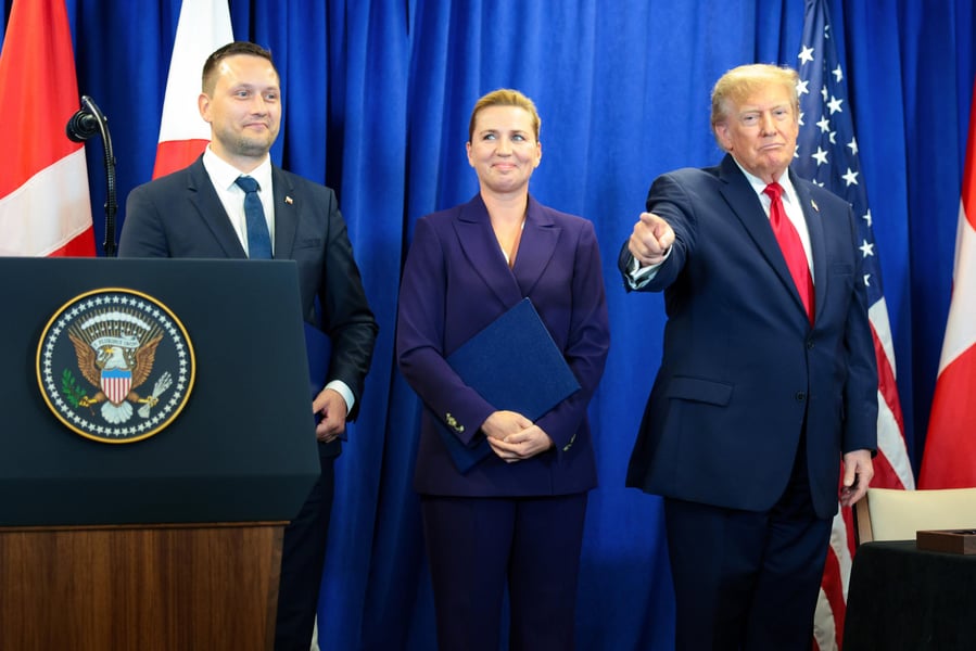 Greenland's prime minister, Denmark's prime minister and President Trump on stage at the signing of the security pact