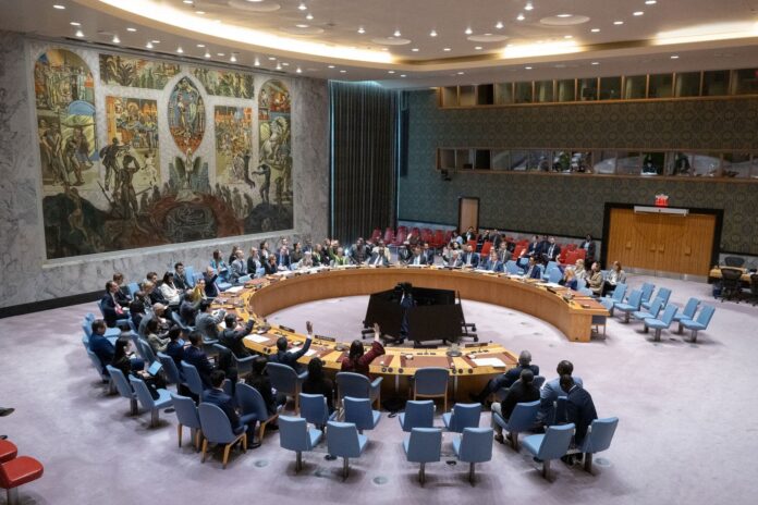 Security Council members raise their hands in the Council chamber at UN headquarters during the vote on Haiti sanctions