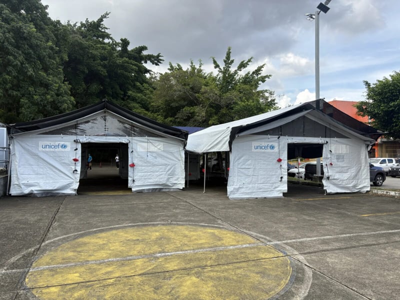 Two white UNICEF-marked tents set up in a hospital car park