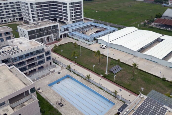 Aerial view of a walled scam compound with office blocks, warehouses and a swimming pool in the Philippines