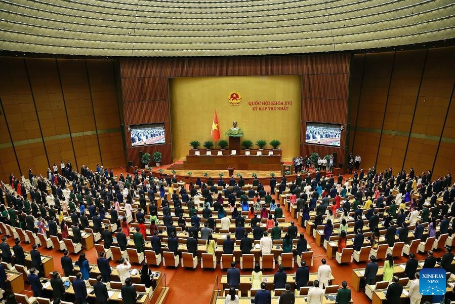 Delegates standing in the National Assembly hall in Hanoi at the opening of the 16th National Assembly's first session