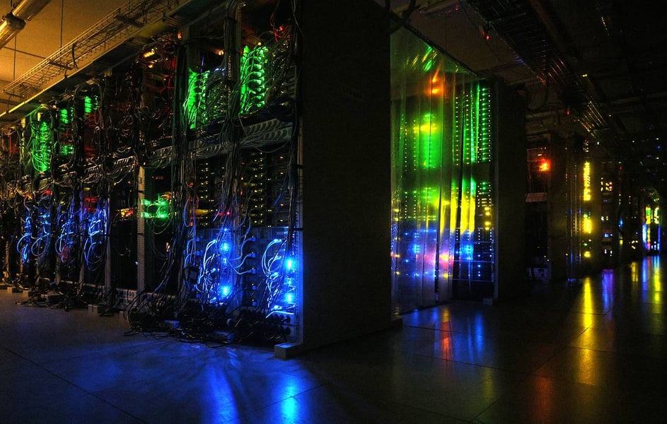 Rows of lit server racks in a dark data center