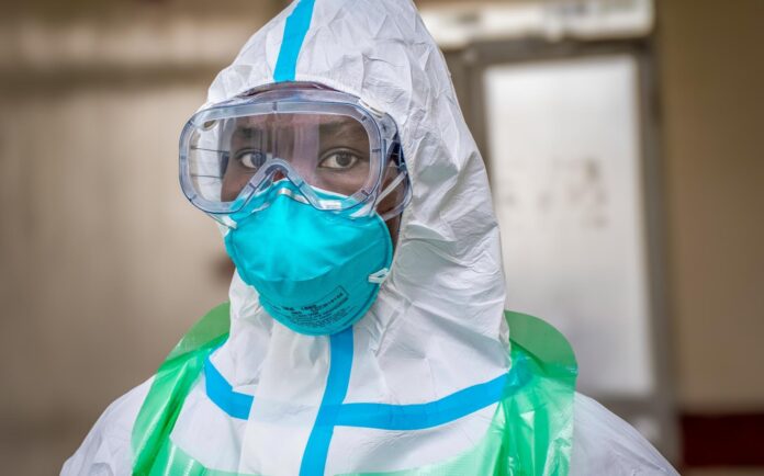 Health worker in a white protective suit, goggles and a teal mask during the Ebola response in Kenya
