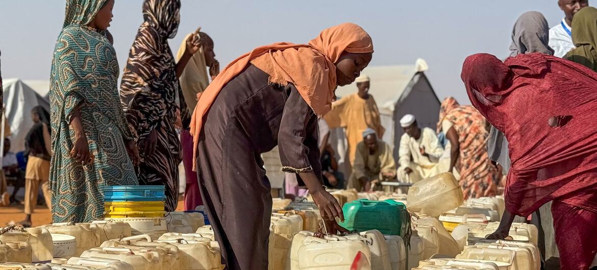 Women and children queue beside rows of water containers in Al Obeid, North Kordofan, Sudan