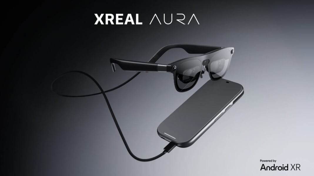 Black Xreal Aura glasses connected by a cable to a rectangular companion device