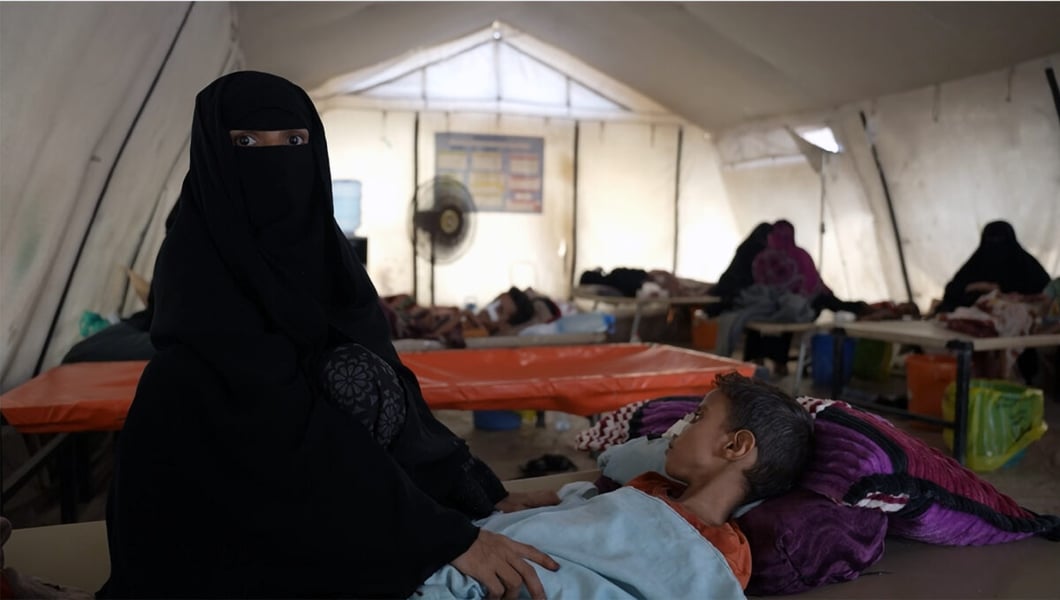 A mother sits beside her child receiving care at the diarrhoea treatment centre in AlSadaqah Hospital, Aden