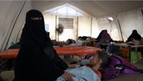 A mother sits beside her child receiving care at the diarrhoea treatment centre in AlSadaqah Hospital, Aden